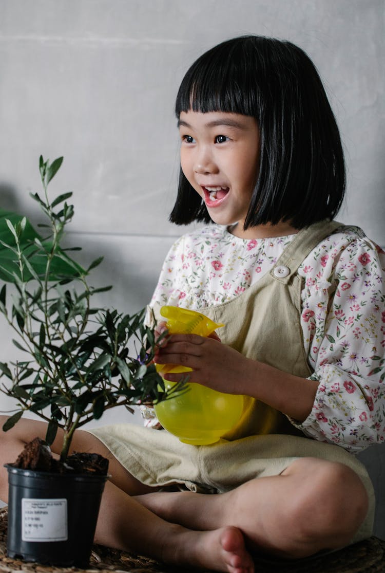 Happy Little Girl With Flowerpot And Water