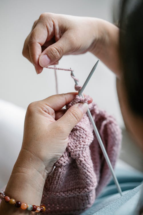 Crop woman knitting apparel at home