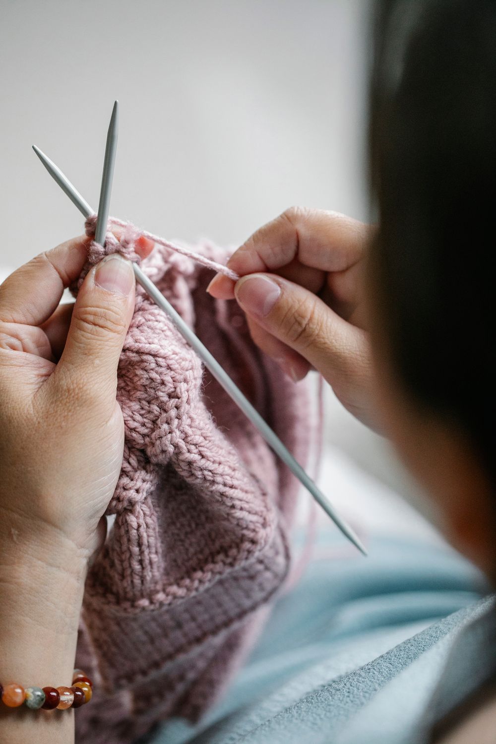 Vrouw die met breinaalden aan een trui werkt