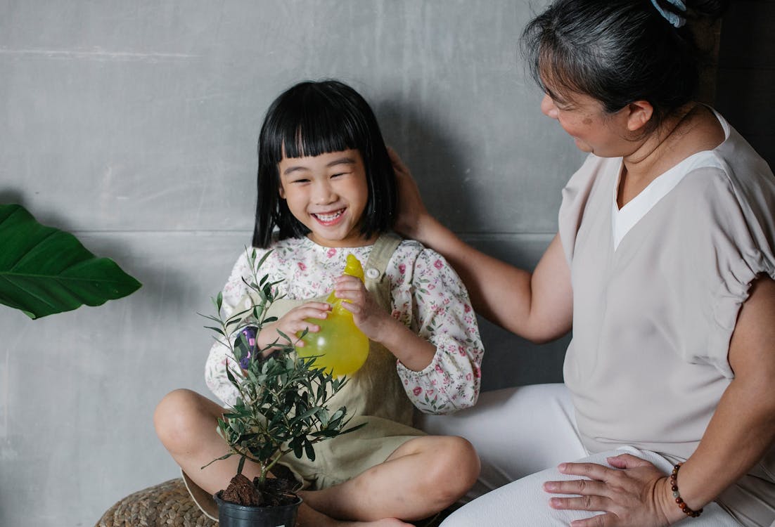 Free Laughing girl with grandmother taking care of plant Stock Photo