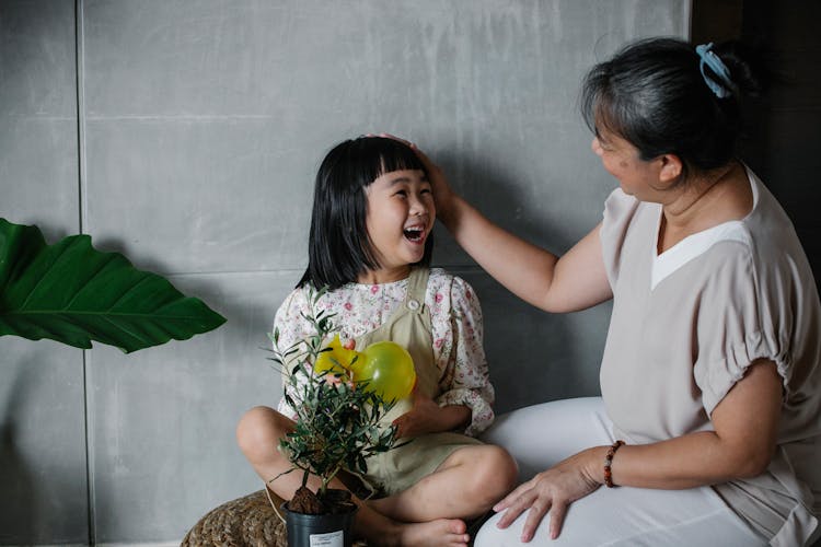 Loving Grandmother With Girl And Flowerpot