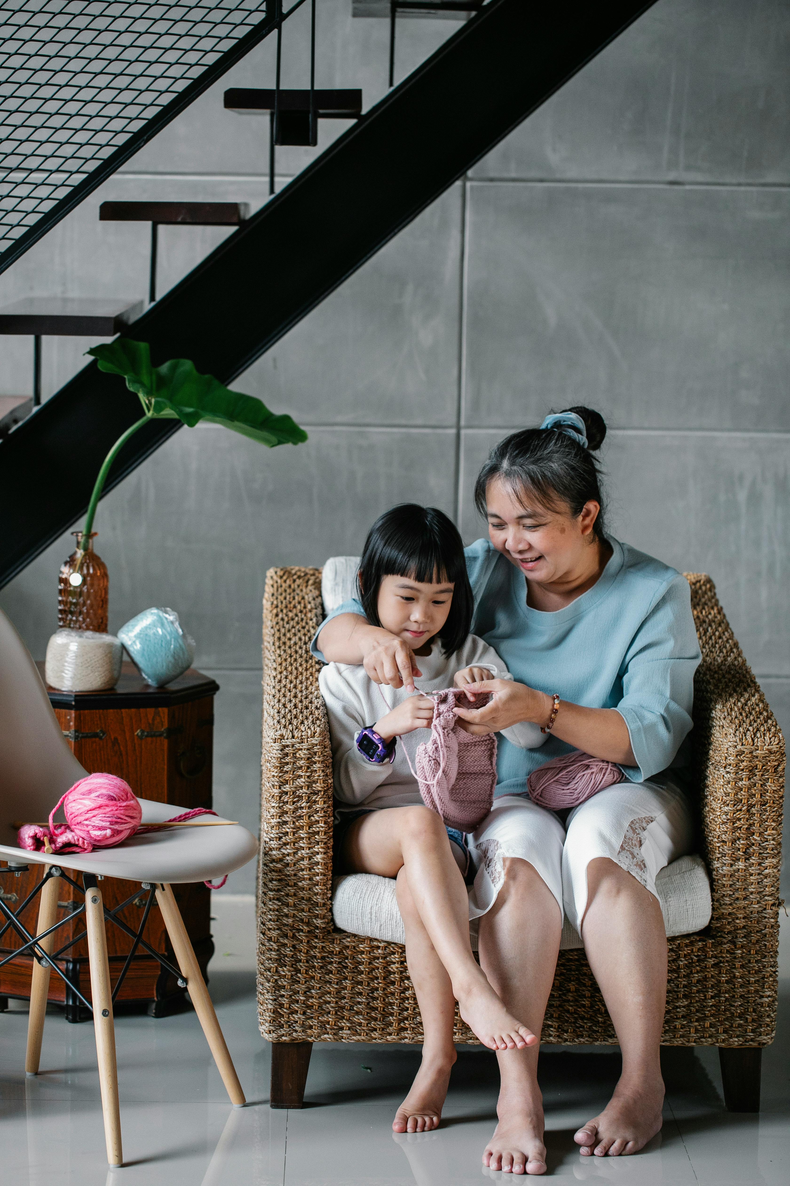 happy woman with granddaughter knitting