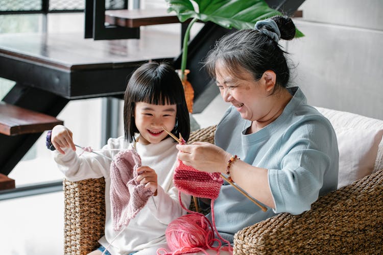 Happy Woman And Girl Knitting At Home