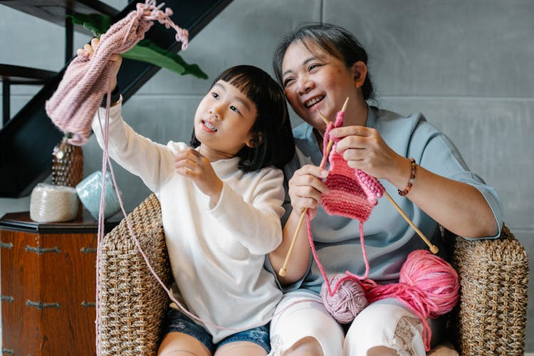 Charming Girl With Grandmother And Knitting