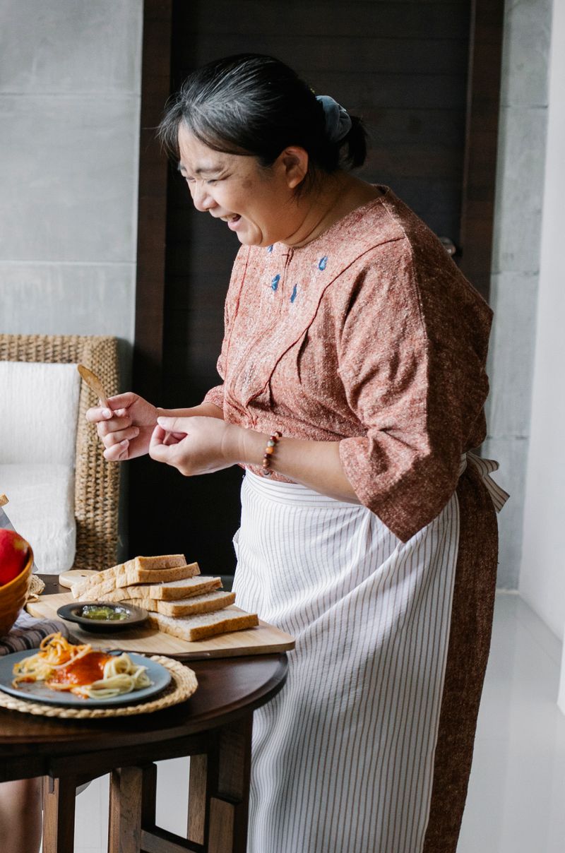 Cheerful senior woman serving lunch at home with caregiver support