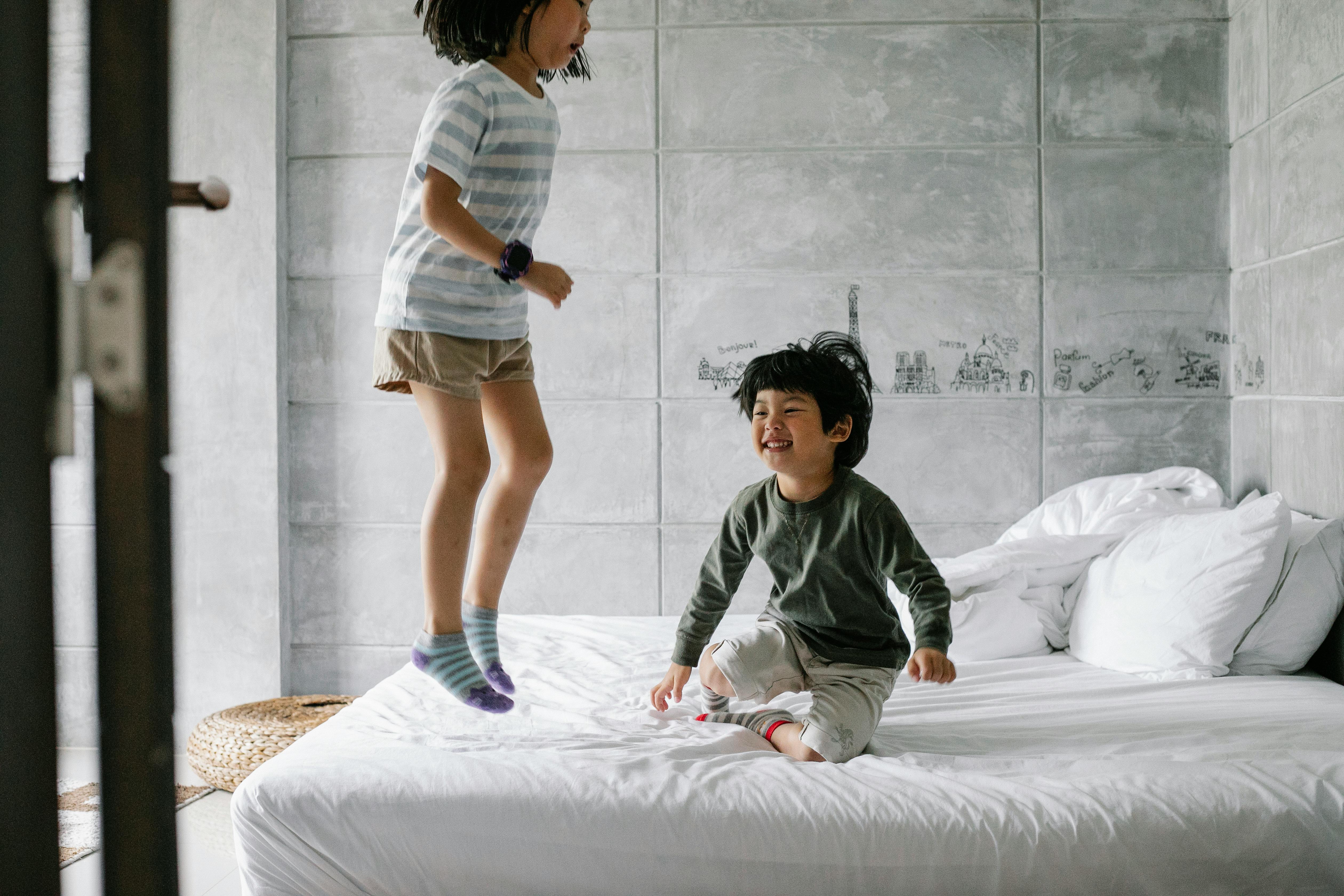 happy ethnic kids having fun on bed