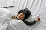 Ethnic boy lying in bed after sleep