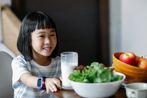 Happy Asian girl drinking milk