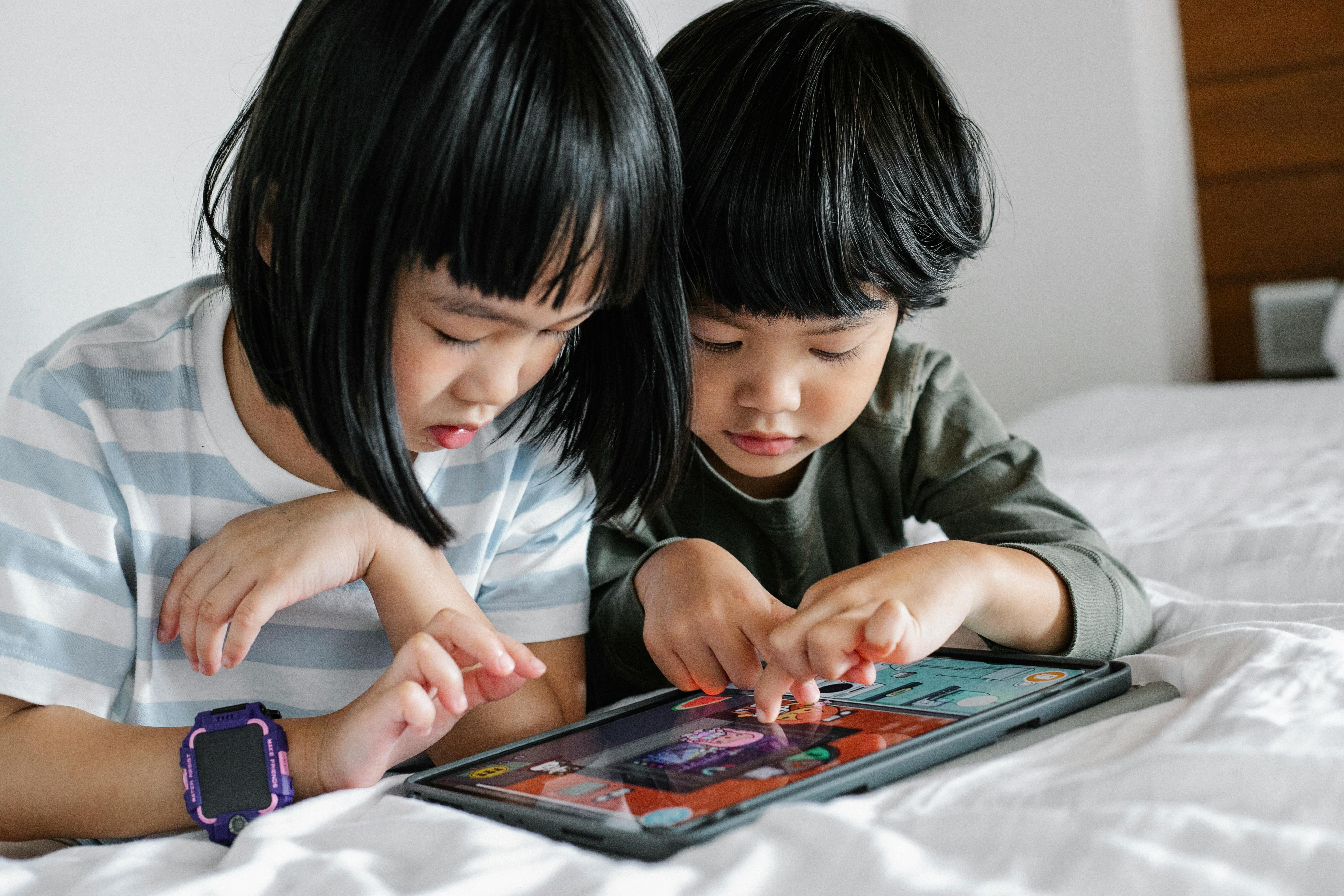 asian kids playing with tablet