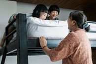 Grandmother near bunk bed with Asian kids