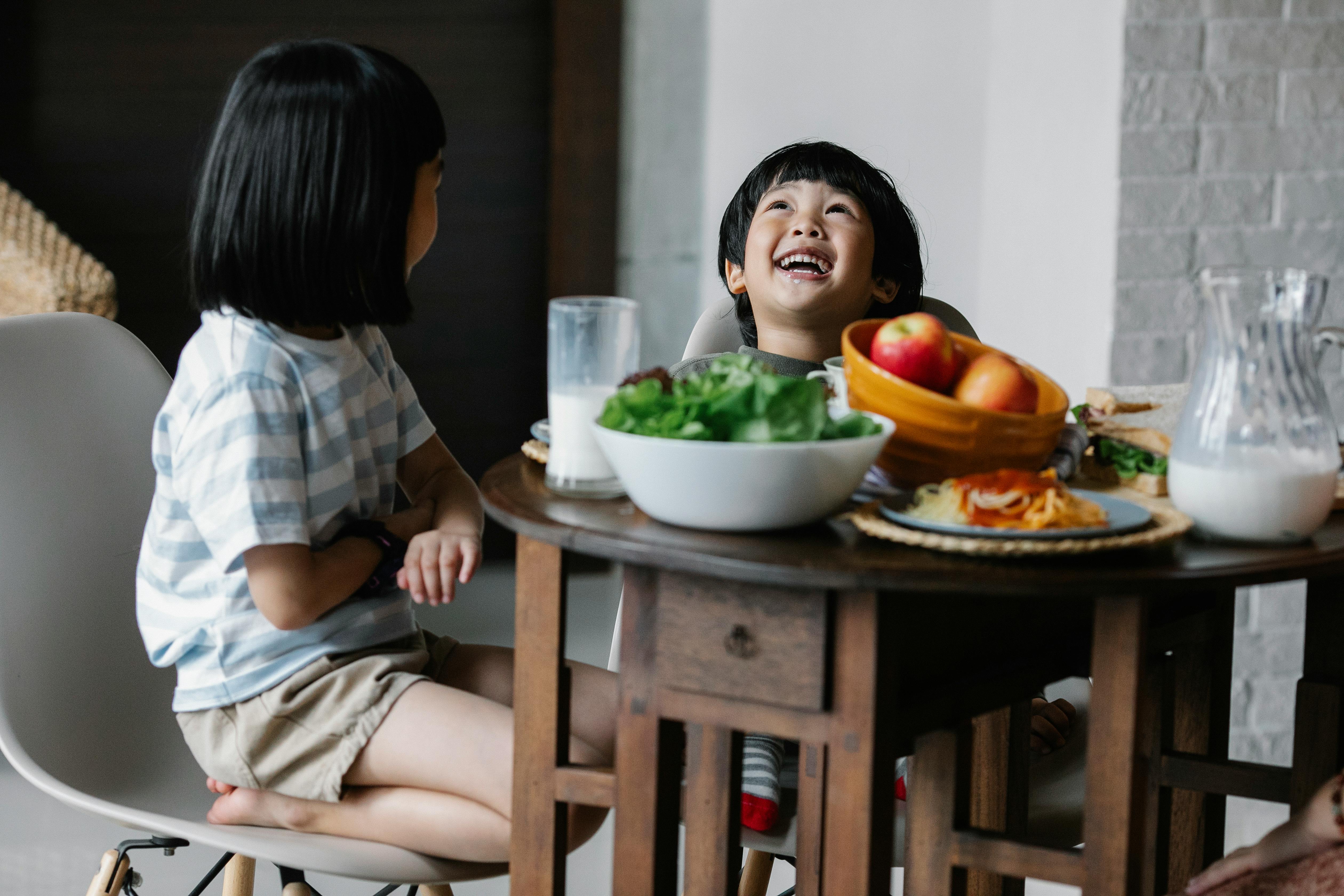 cheerful asian children having breakfast