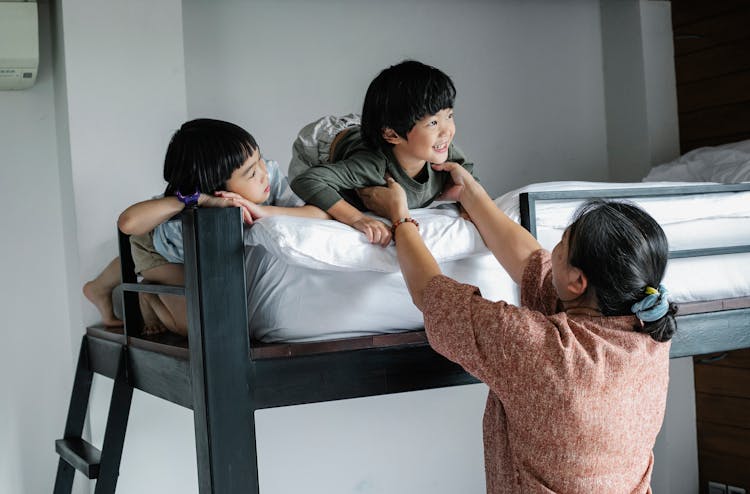 Asian Kids On Bunk Bed Near Grandmother