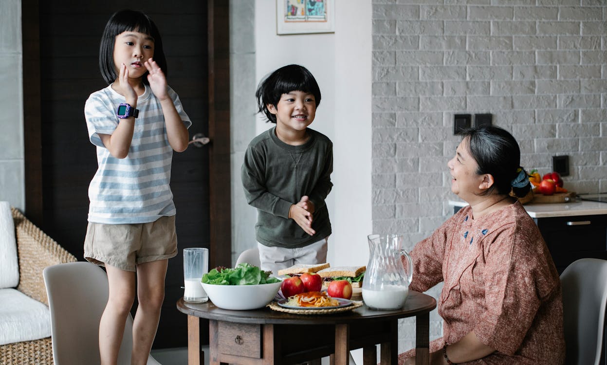 Cheerful Asian kids having fun in kitchen