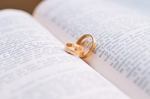 Deux Bandes De Mariage De Couleur Or Sur La Page Du Livre