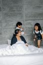 Active children running on bed around sitting grandmother