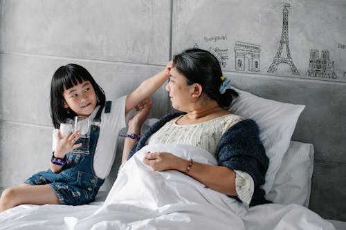 Adorable Enfant Asiatique Touchant Le Front De La Grand Mère Malade