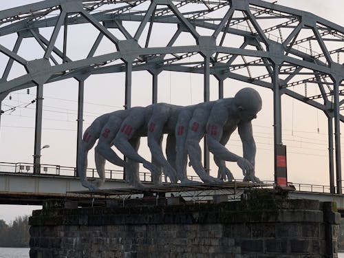 A Gray Statue Near The Bridge