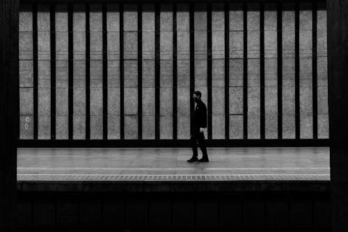 Grayscale Photo of a Person Walking 