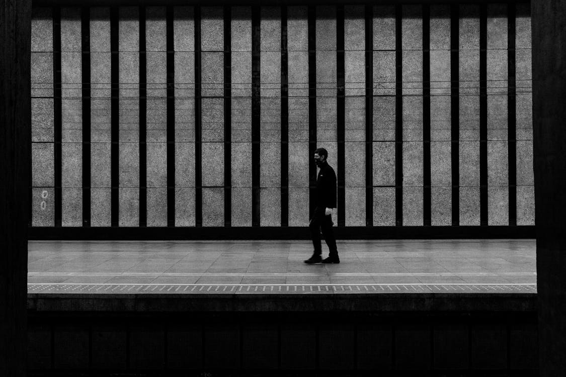 Grayscale Photo of a Person Walking 