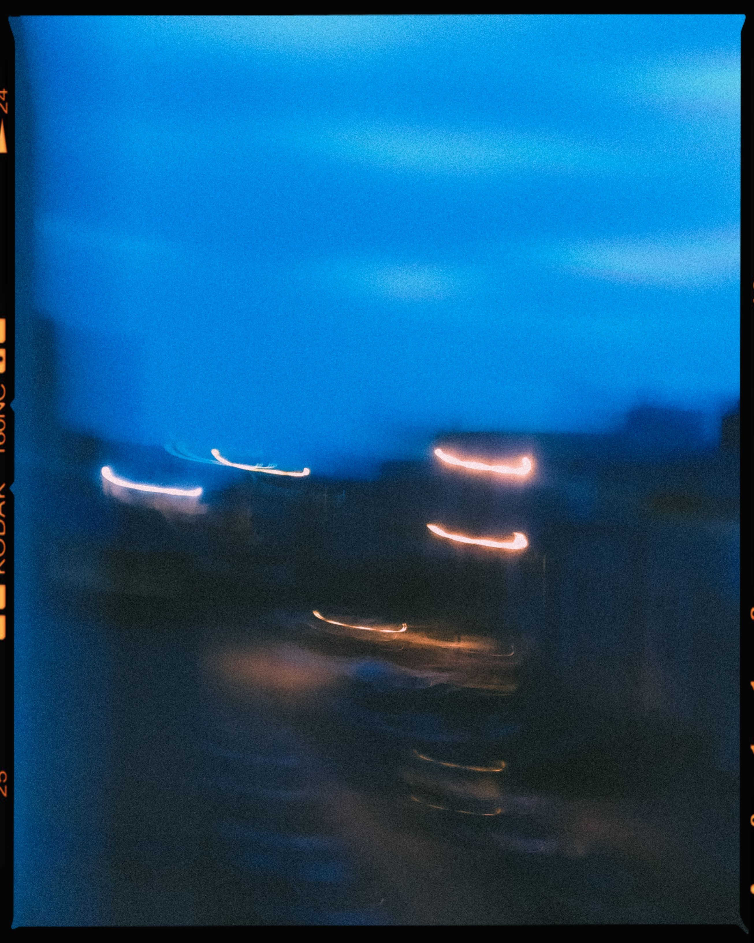 Abstract blurred night cityscape with vibrant lights and motion blur effects.