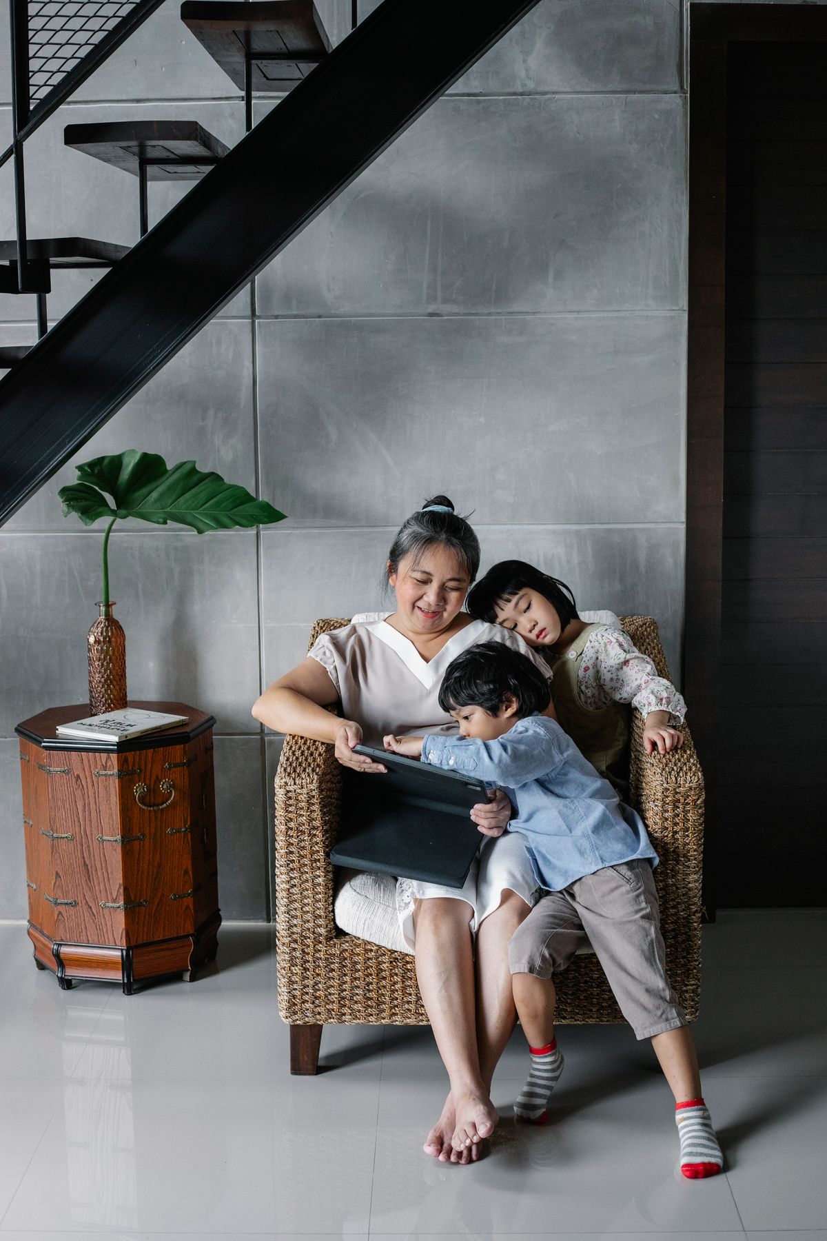 Malaysian grandmother at home with her grandchildren, the household a home oxygen setup serves