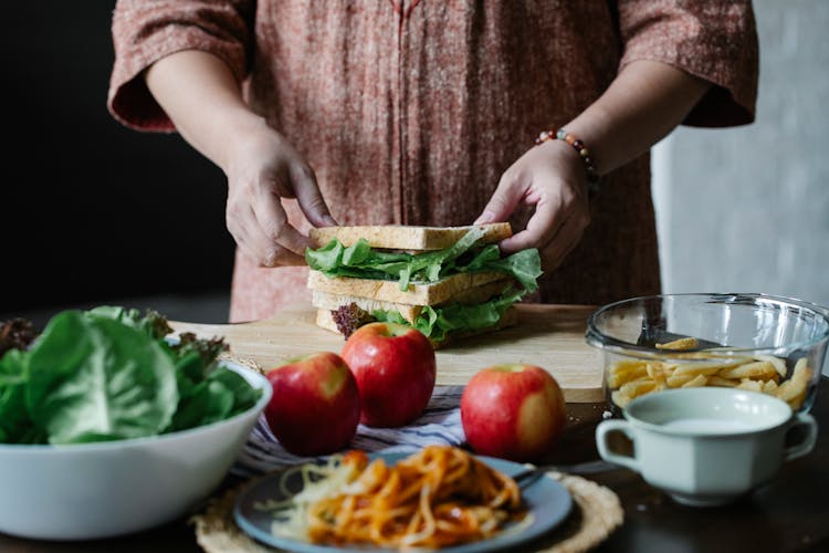 Crop Woman Cooking Healthy Sandwich On Wooden Board