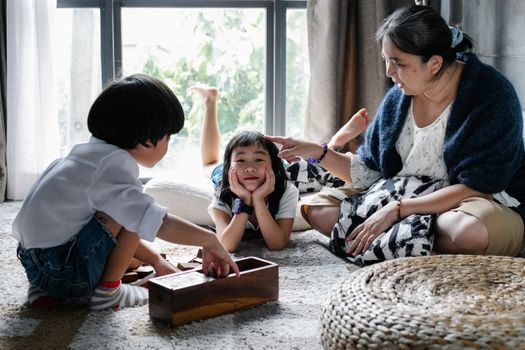 祖母和她的孙子们在室内玩游戏，共度美好时光