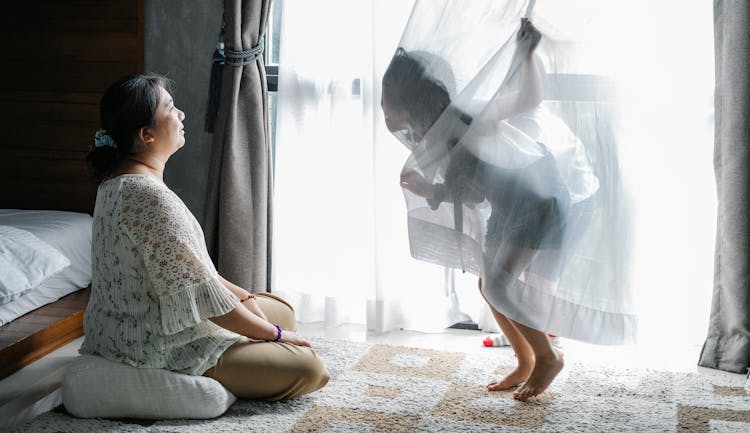 Senior Woman Playing With Kids In Bedroom