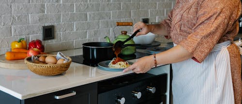 Free Ernte Unerkennbare Hausfrau, Die Spaghetti In Der Küche Tomatensauce Hinzufügt Stock Photo