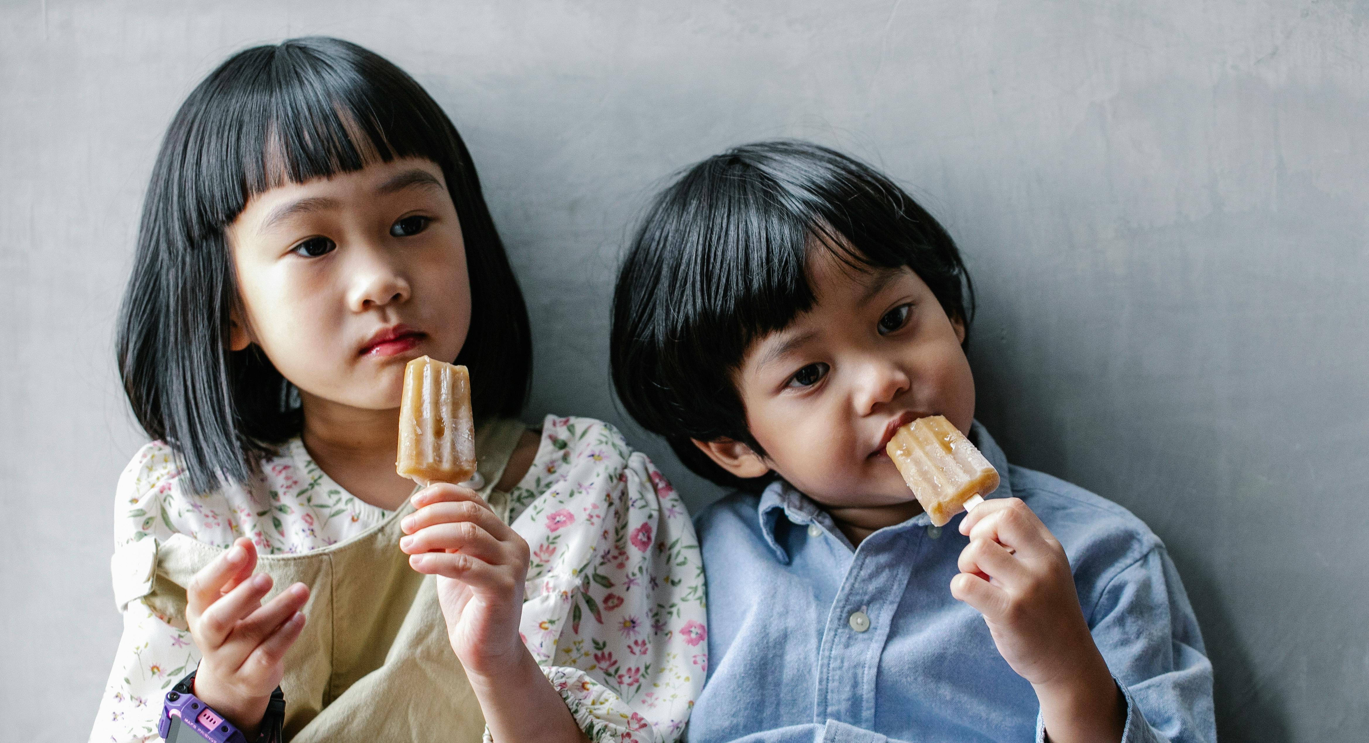 adorable asian kids enjoying sweet ice cream