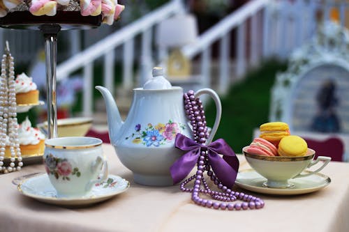 Close-up of Porcelain Tea Set and Sweet Snacks on the Table Outside 