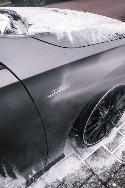 Free Close-up of a sleek black car being washed with foam, highlighting its shiny surface and modern design. Stock Photo