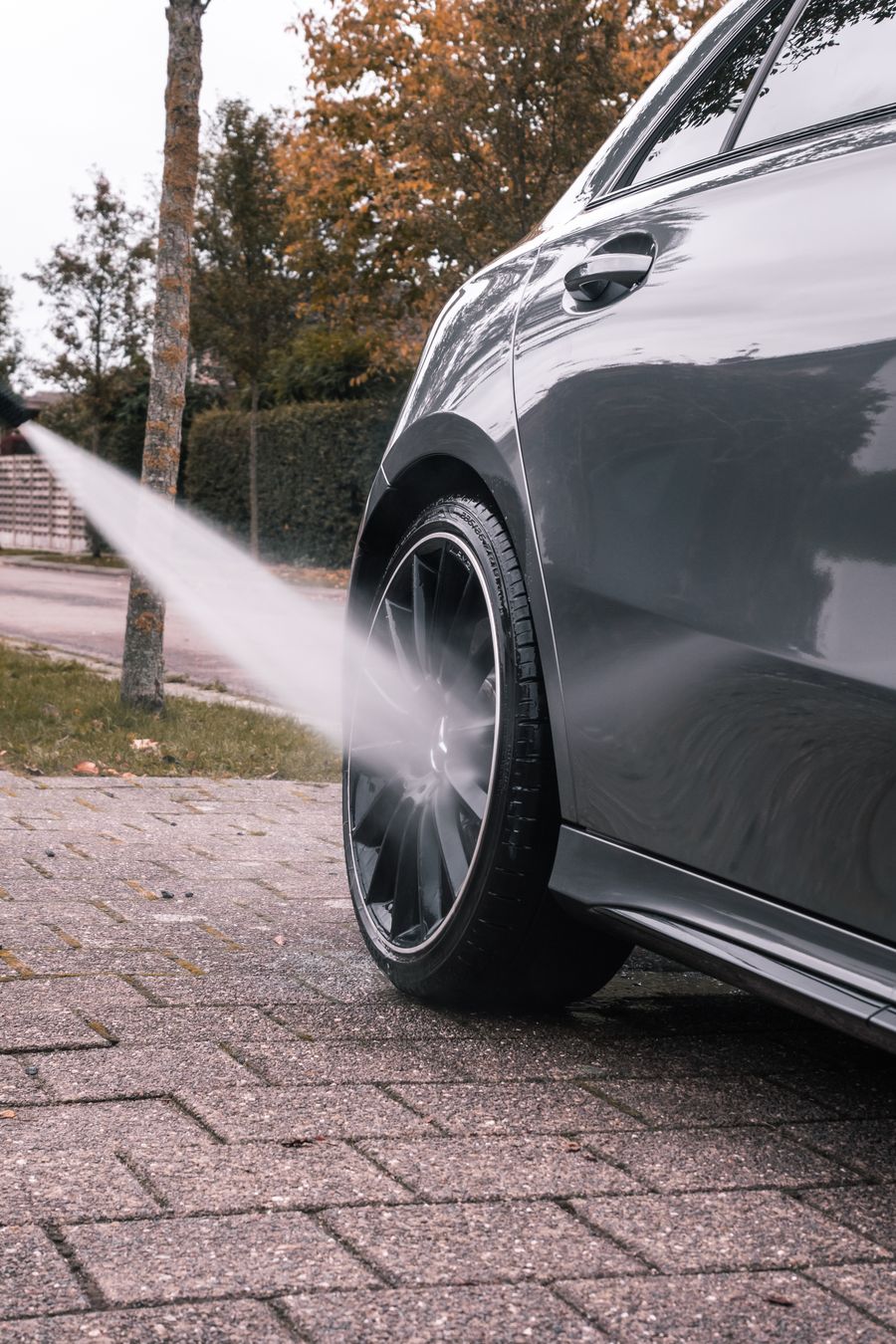 Pressure washing a concrete driveway, revealing a clean path