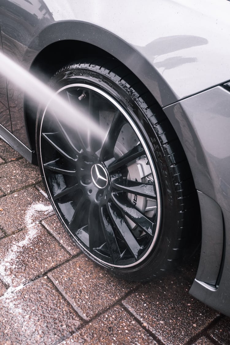 Close Up Of Water Stream Cleaning Car Wheel