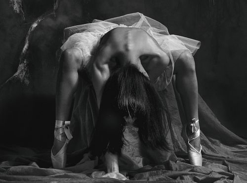 Free Artistic black and white photo of a ballerina in a dramatic pose in studio. Stock Photo