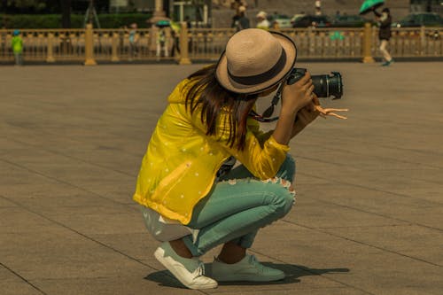 Femme Assise Sur Le Trottoir Tout En Prenant Une Photo