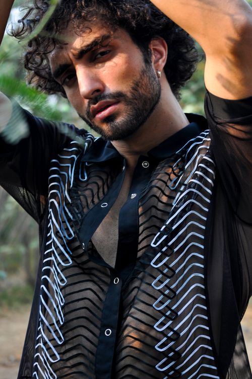 Free Portrait of a bearded man in a see-through shirt posing outdoors. Stock Photo