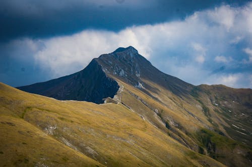 Clouds over Grass Covered Mountain