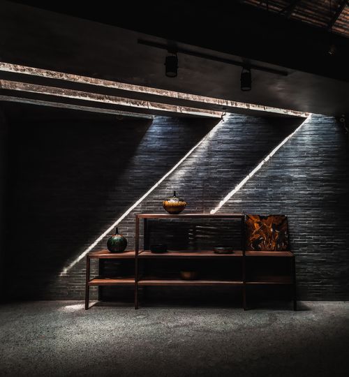Free A modern interior space with unique lighting casting diagonal shadows on a textured wall. Stock Photo