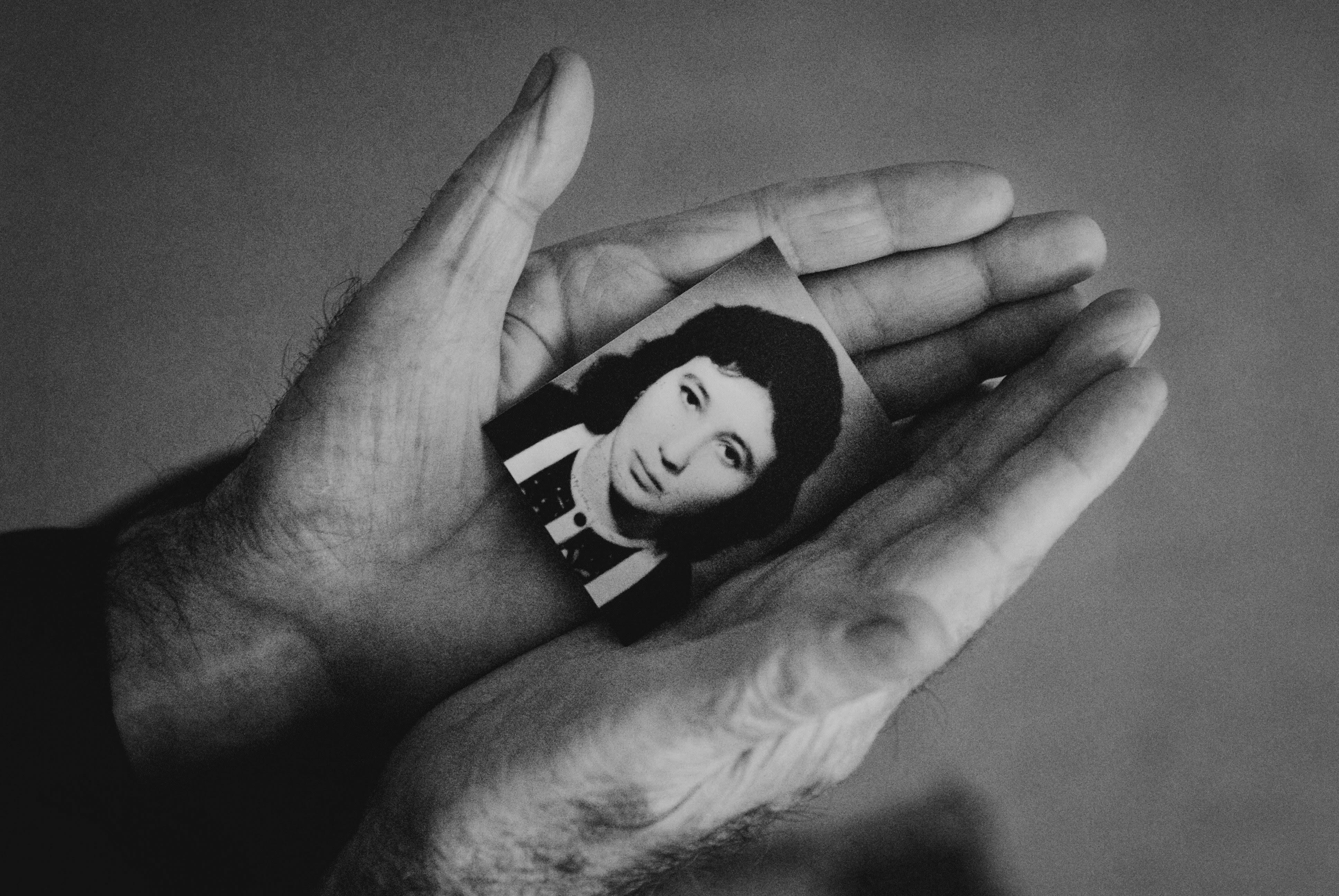 unrecognizable man carrying old picture of girl in hands