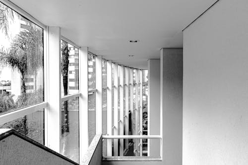 Black and white contemporary building corridor with stairway and big windows in daylight