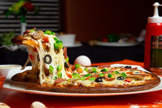 Delicious pizza slice with mozzarella and toppings being lifted. Perfect for food photography.