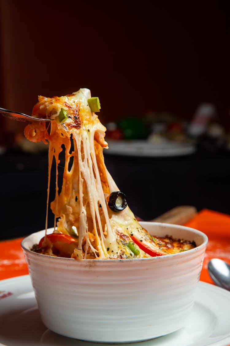 Close-up Of Person Eating Cheese Dish 