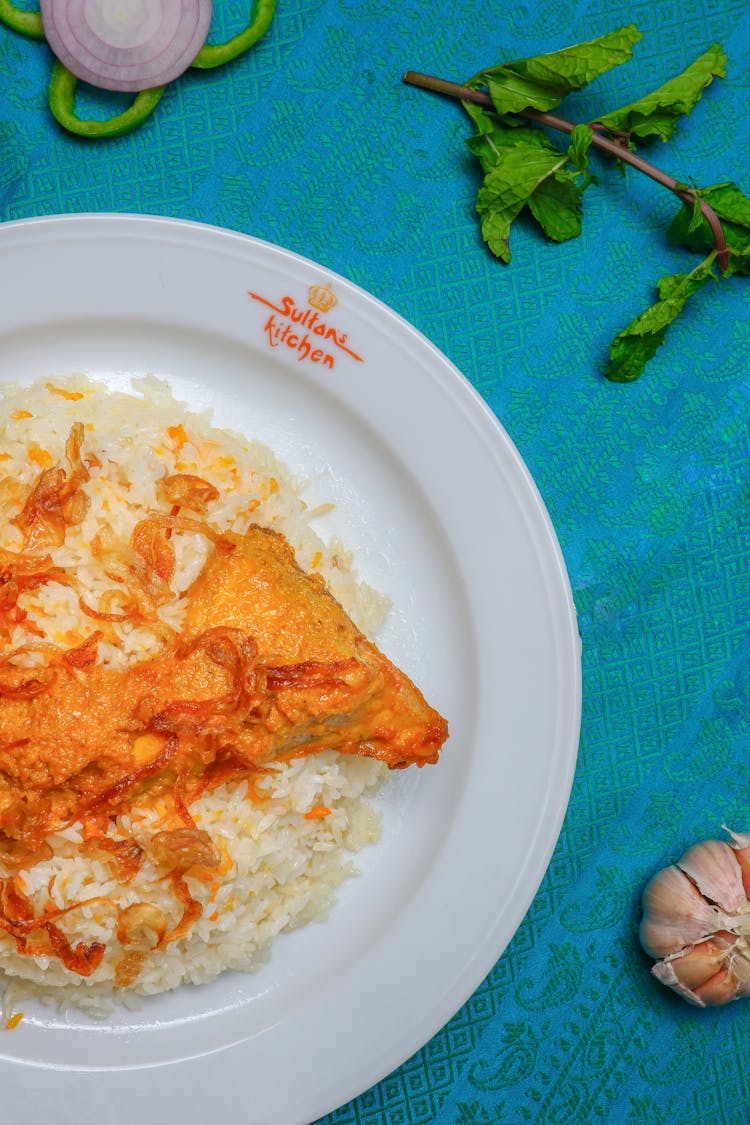 A Plate Of Rice With A Delicious Chicken Topped With Strips Of Caramelized Onions