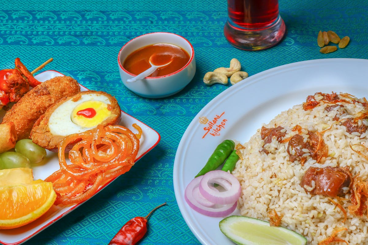 Raw chicken breast pieces and chopped colorful vegetables on a cutting board