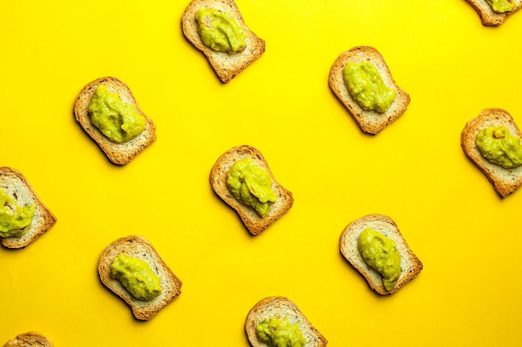 Toasts With Yummy Guacamole Placed On Yellow Background