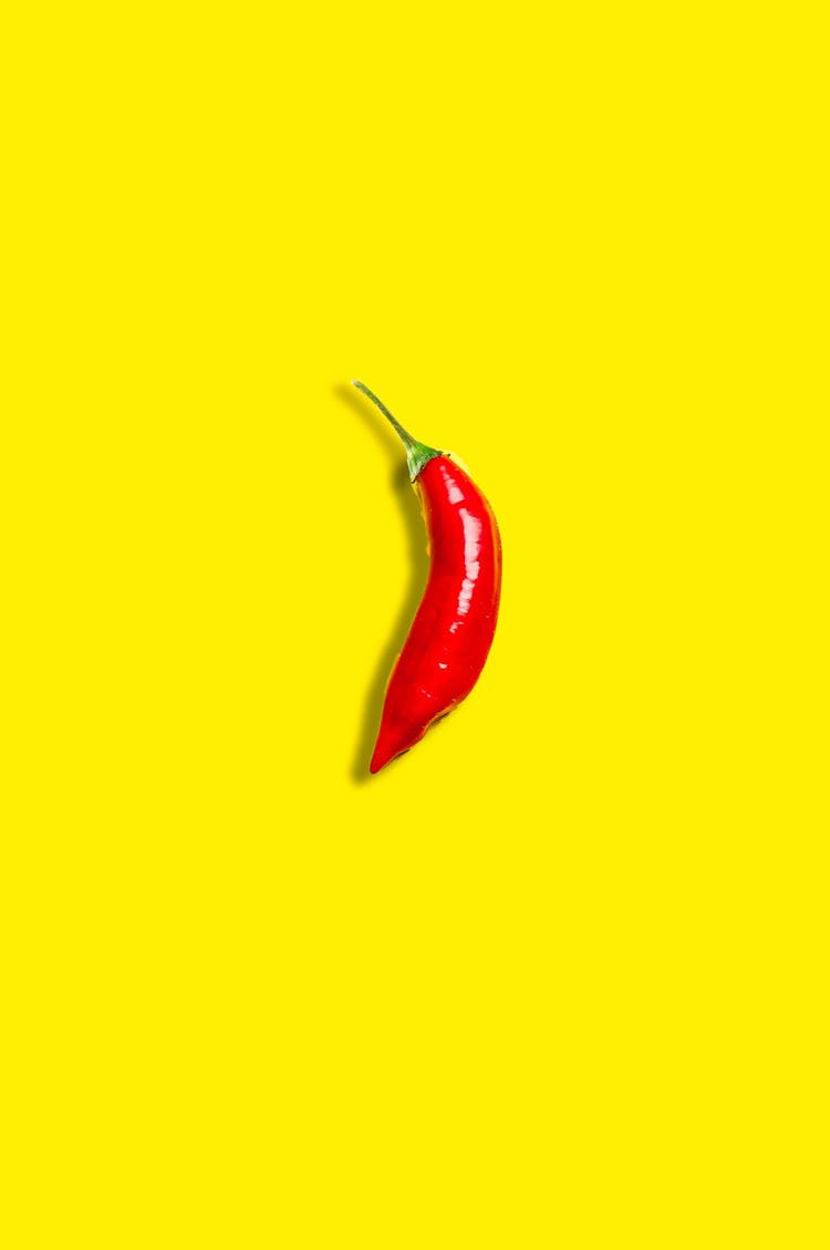 Red Pepper Placed On Yellow Background