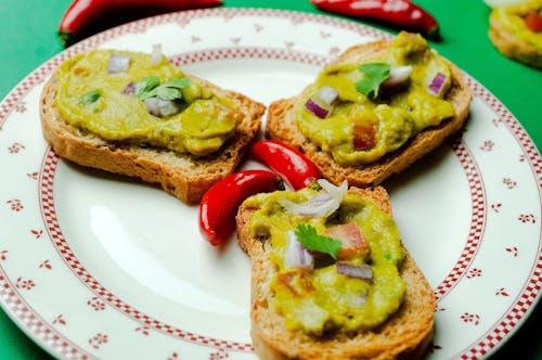 Free High angle savory toasts with guacamole served on plate and decorated with chili pepper Stock Photo
