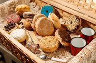From above of cookies and donuts in wooden basket with spoons and cups