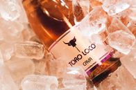 From above of bottle of wine with logo of bull placed in cold ice cubes